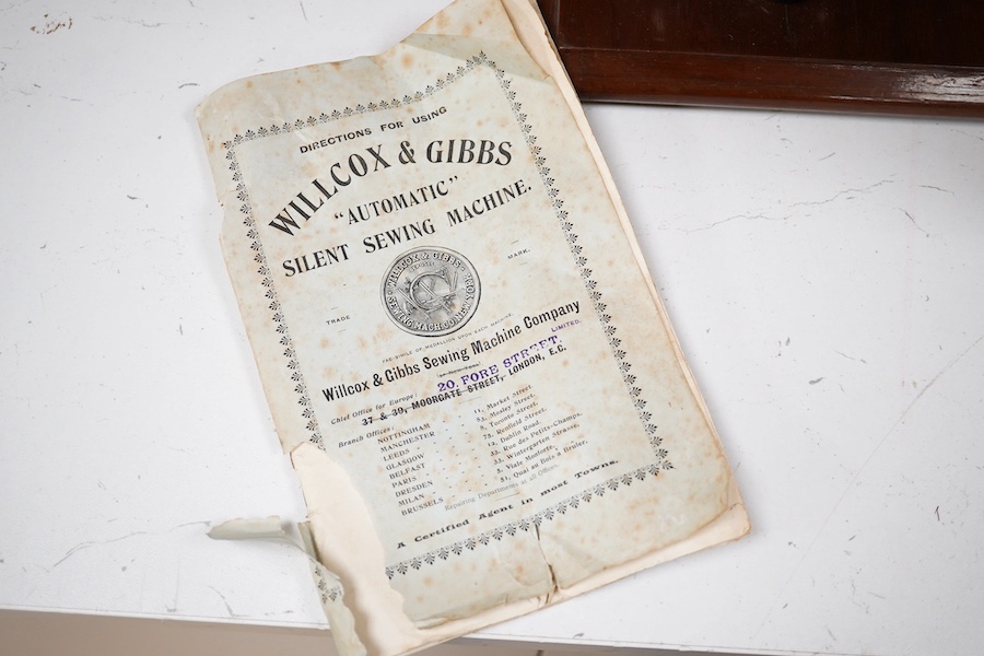 A late 19th century Willcox & Gibbs Automatic Silent Sewing Machine, with its instruction booklet and pine case. Condition - good.